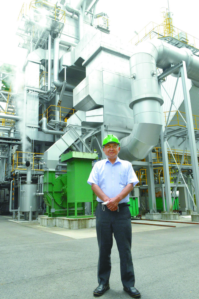 トーセンの東泉清寿社長と那珂川バイオマス発電所のプラント。製材工場と隣接するバイオマス発電所を拠点にした半径50㌔㍍の経済圏構想「エネルフォーレ50」を推進します