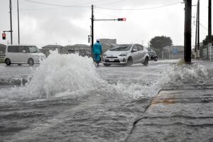道路のマンホールから水が噴き出し一部通行止めとなった交差点＝４日午後１時55分、宇都宮市上横田町