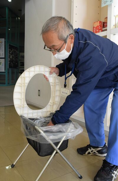 簡易式トイレの使い方を実演する駒田館長