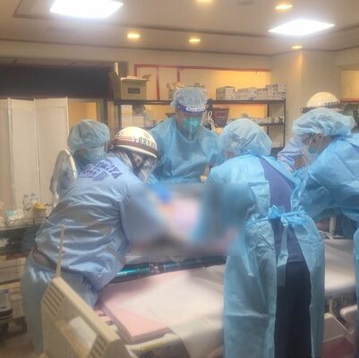 臨時医療施設で患者対応に当たる医療従事者と救急隊員＝昨年12月下旬（県提供、画像は一部加工しています）