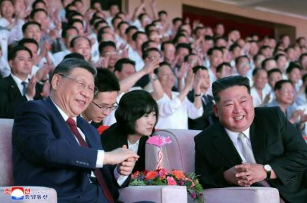 眼鏡をかけて芸術公演を鑑賞する中国の習近平国家主席。右は北朝鮮の金正恩朝鮮労働党総書記=8日、平壌(朝鮮中央通信=共同)