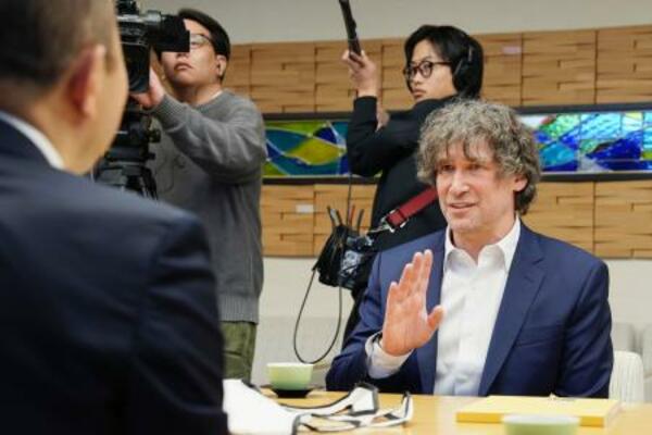 長崎市役所で鈴木史朗市長(左)と面会する米シカゴ大のダニエル・ホルツ教授=9日午前