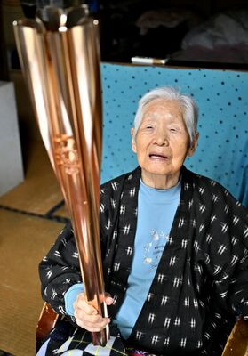 聖火リレーで掲げたトーチを手に思い出を語る箱石さん＝４日午前、那珂川町谷川