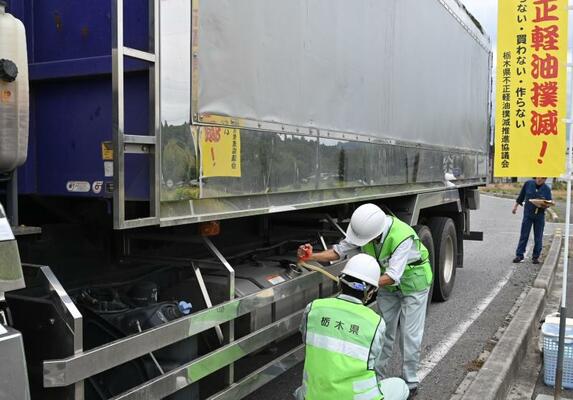 大型トラックから軽油を抜き取る県職員