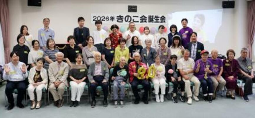 「きのこ会」の誕生会で、写真に納まる原爆小頭症の被爆者と家族ら=20日午後、広島市