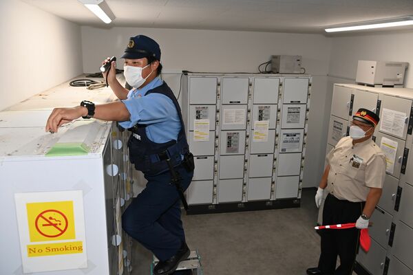 東武日光駅にあるロッカーの上を調べる警察官ら