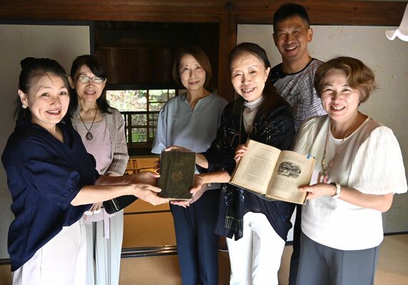 歴史館の担当者（左）に原書を手渡す研究会のメンバー