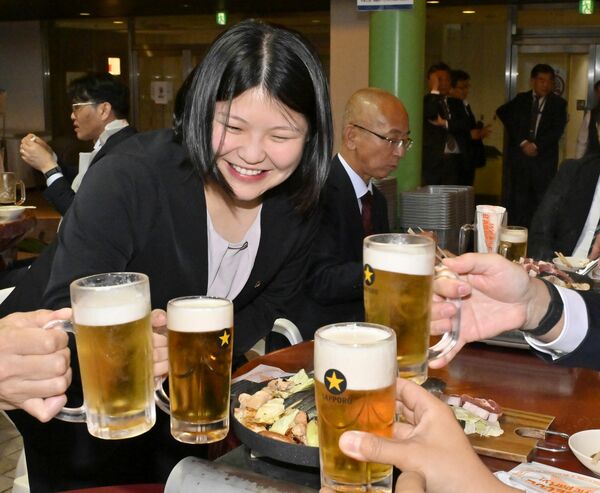 ビールを片手に笑顔で乾杯する会社員ら