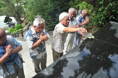荒井退造「終焉之地」碑に生家の水を手向ける荒井俊典さん(左から3人目)ら=6月26日午後2時30分、沖縄県糸満市摩文仁の平和祈念公園