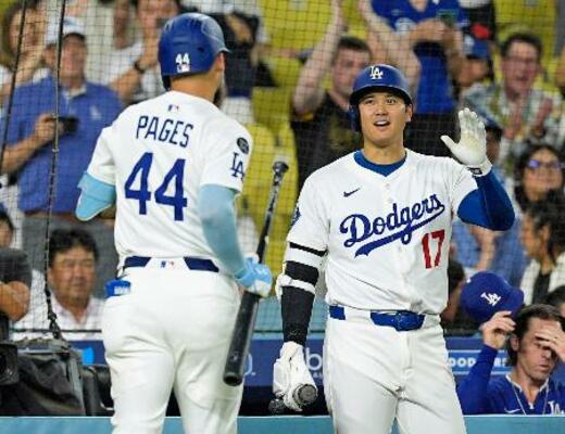 　レッズ戦の８回、左犠飛を放ったパヘス（左）を迎えるドジャース・大谷＝ロサンゼルス（共同）