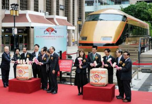 　台北駅前に展示された東武鉄道の特急「日光詣スペーシア」と式典出席者ら＝１８日、台北市（共同）