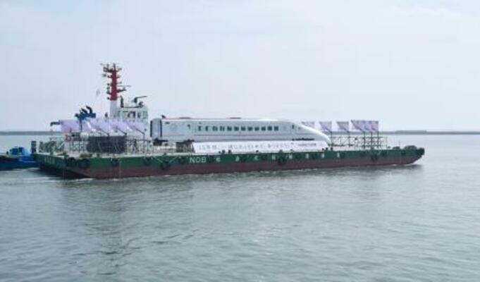 　熊本港を船で出発する九州新幹線つばめの車両＝２９日午後、熊本市