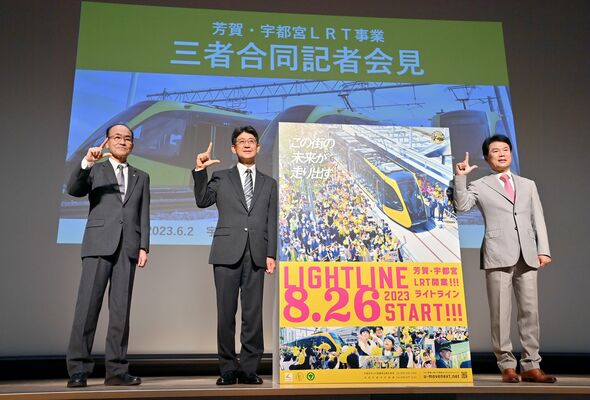 会見でＬＲＴの８月26日開業を発表し、右手で「Ｌ」のポーズをとる（右から）佐藤市長、大関町長、高井社長＝２日午後１時10分、宇都宮市宮みらい