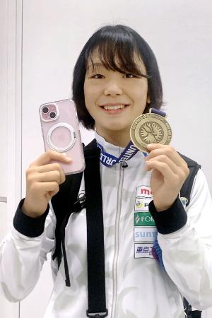 　成田空港に帰国し、金メダルと手元に戻ったスマートフォンを手に笑顔を見せるレスリングの藤波朱理＝２７日