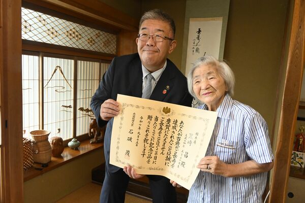 中村市長（左）から長寿の祝いを受けた黒崎さん