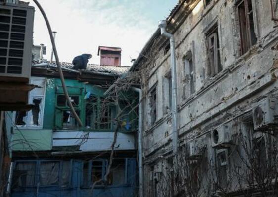ロシアの攻撃があった現場で被害を受けた建物を調べる住人=13日、ウクライナ・オデーサ(ロイター=共同)