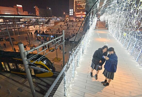 ライトラインが走る中、電飾で彩られた宮みらいライトヒル＝15日午後６時35分、宇都宮市宮みらい