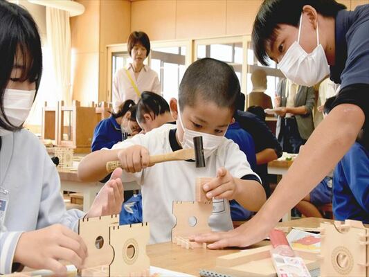 真岡工業高生徒に教わりながら真剣な表情で作業に取り組む児童たち