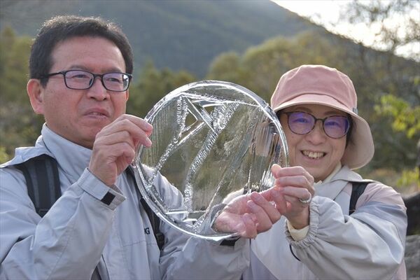 バケツに張った氷を手にする観光客＝８日午前７時２０分、日光市中宮祠