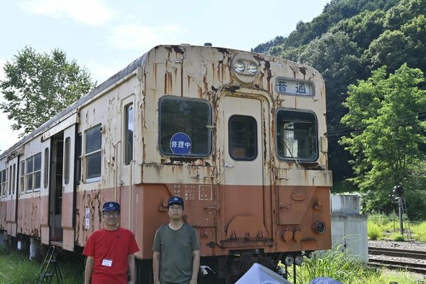 修繕予定の「キハ30　35」とあしおトロッコ館の北川さん（左）と諏訪戸さん＝９日午後、日光市足尾町