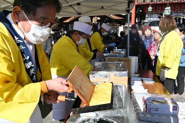参拝者らに焼きたての卵焼きを振る舞う太平山観光会のメンバー