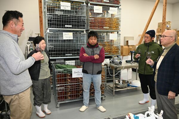 ワインを試飲して感想を述べ、意見を交換する視察者と吉村さん夫妻（左）＝２月８日、宇都宮市新里