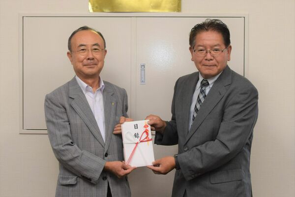目録を手渡す石塚満さん（左）と受け取る森山和夫会長（右）