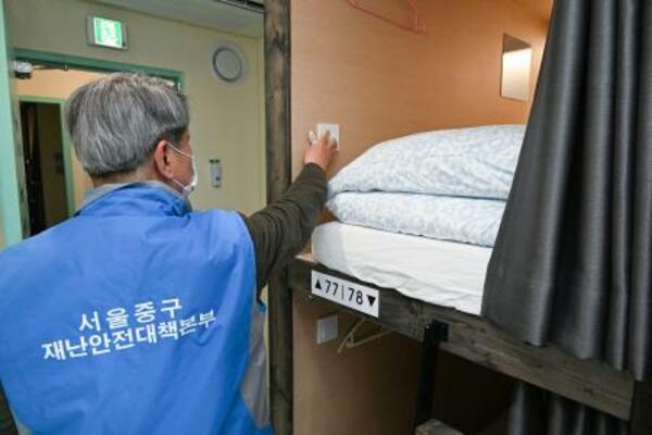 16日、ソウル市内のカプセルホテルの安全点検を行う区の関係者(共同)