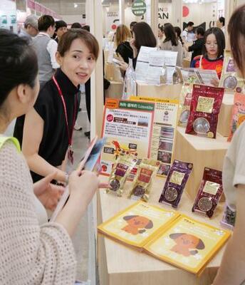 「台北ペットショー」で自社製品を紹介するオリエント商会の田畑千子専務(左から2人目)=3日、台北市(共同)