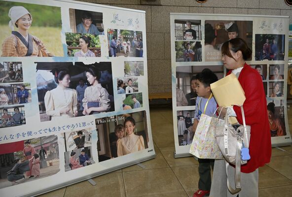 巡回展で設置された大型の写真を眺める清水さん親子＝24日午後、県立博物館
