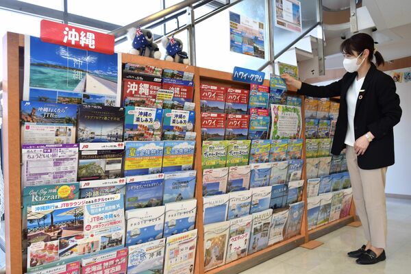 多数の旅行案内のパンフレットが並ぶ旅行代理店＝4月中旬、宇都宮市池上町