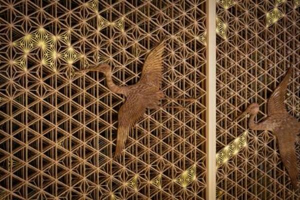 　八芳園メインロビー壁面を飾る福岡県大川市の組子細工。夫婦鶴の彫刻をあしらった（提供写真）