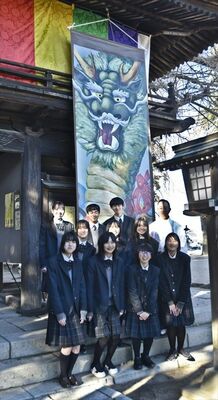 大掛け軸の前で記念撮影する生徒たち