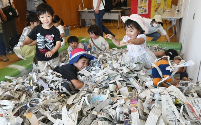 新聞紙のプールで遊ぶ子どもたち