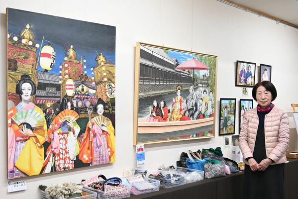 鮮やかな色鉛筆画と並ぶ癸生川さん