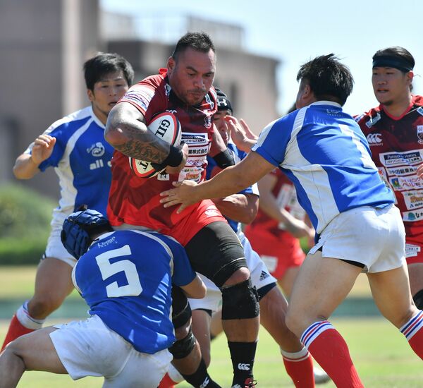 開幕戦でタックルを受けながら突き進むロアマヌ=足利ガスグラウンド