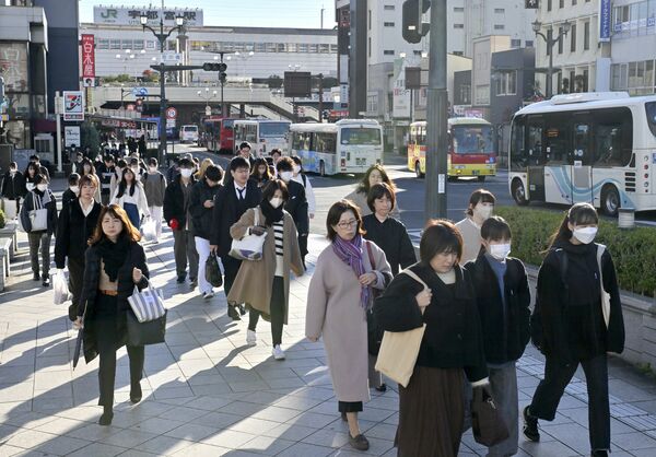 厚着姿で通勤、通学する人たち=19日午前8時30分、宇都宮市駅前通り1丁目