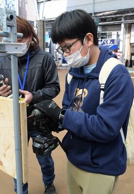 機械を使ったくぎ打ちを体験する来場者