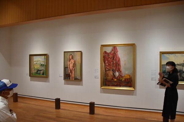 ギャラリートークで作品を解説する清水学芸員（右）＝16日午前、日光市山内