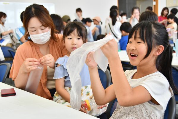 理科実験教室で傘袋を使ったロケット作りを楽しむ参加者