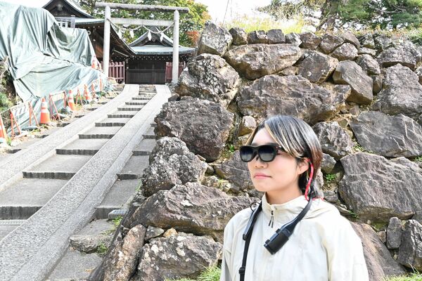 本丸付近でスマートグラスをかけて映像を見る記者