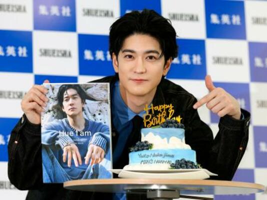 　サプライズで用意された誕生日ケーキを前に、写真集を手にする中島裕翔＝５日、東京都千代田区