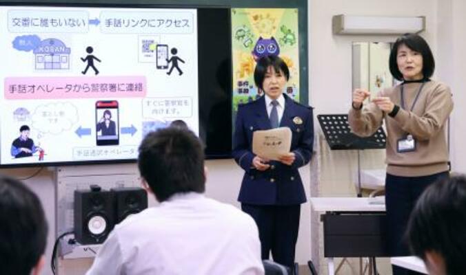 　茨城県立水戸聾学校で開かれた地域安全教室で「手話リンク」について説明する警察官（右から２人目）と手話で通訳する教諭（右端）＝２４日午後、水戸市