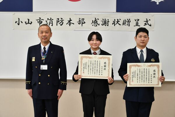 諏訪消防長（左）から感謝状を受け取った阿部さん（中央）と菅野巡査長