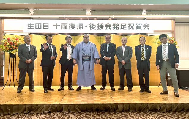 祝賀会で記念撮影する生田目（左から４人目）と後援会の役員＝宇都宮市