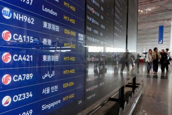 北京首都空港の出発ロビーで羽田空港行きの便が表示された電光掲示板=15日(共同)