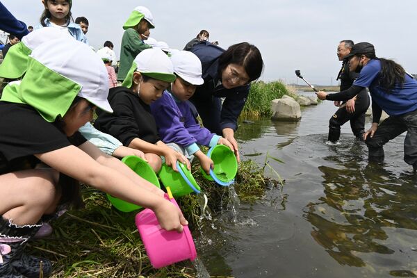 那珂川で稚アユを放流する園児たち