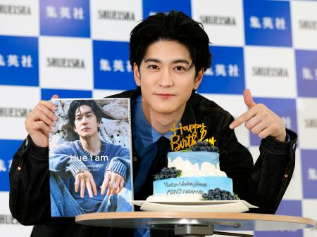 　サプライズで用意された誕生日ケーキを前に、写真集を手にする中島裕翔＝５日、東京都千代田区