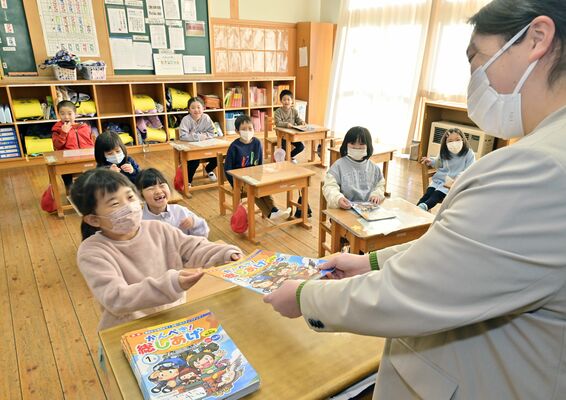 先生に宿題を笑顔で手渡す児童たち＝９日午前８時50分、市貝町文谷