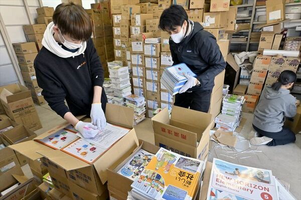教科書を学年や教科別に数えて箱詰めする書店員ら＝14日午前10時35分、芳賀町祖母井南１丁目